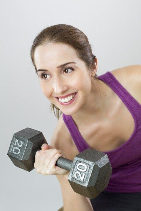 girl holding weights exercising to lose weight